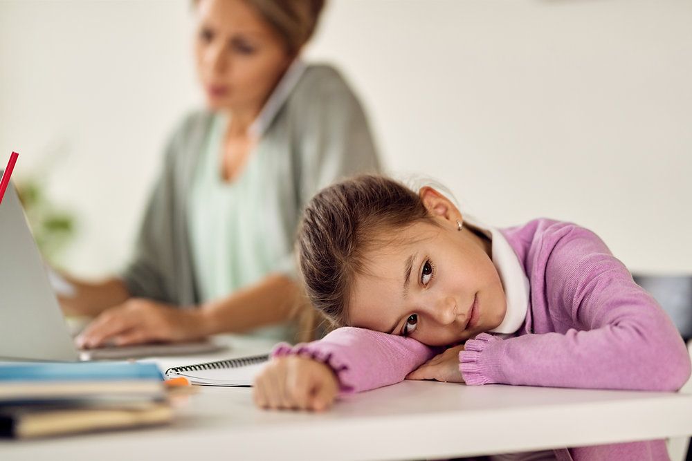 Child struggling to concentrate during homework while parents show concern, highlighting early ADHD symptoms and the importance of professional support.